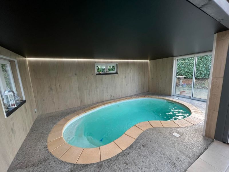 Installation d’un plafond tendu noir pour une piscine intérieure